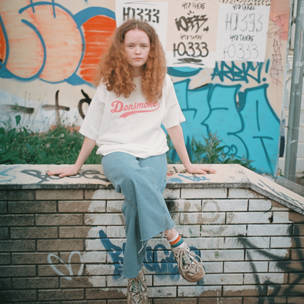 Young person sitting on a wall